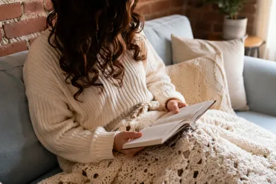 Cozy Woman Reading Bible on Blue Sofa