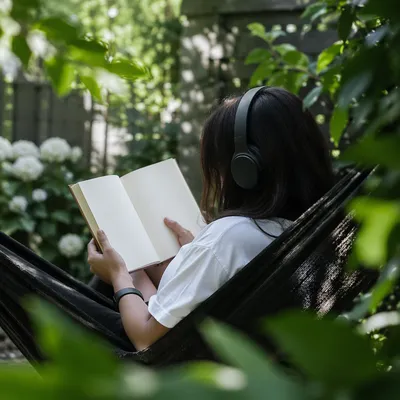 Woman Reading in a Sunny Garden Hammock