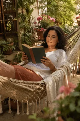 Woman Reading Book in Garden Hammock