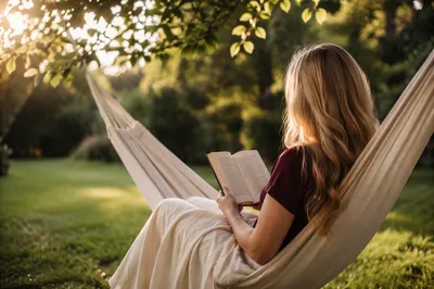 Woman Reading in Garden Hammock at Sunset