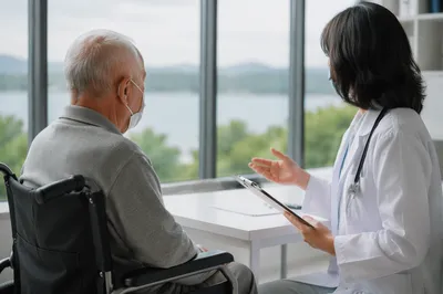 Doctor Consulting Elderly Patient in Clinic