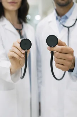Doctors Holding Stethoscopes in Hospital Corridor