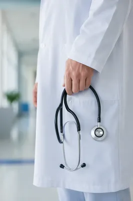 Doctor Holding Stethoscope in Hospital Corridor