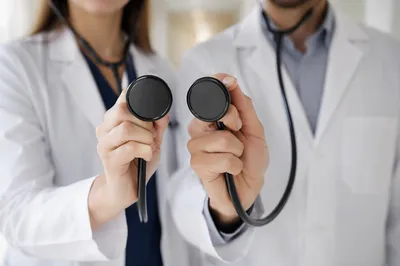 Doctors Holding Stethoscopes in Hospital Corridor
