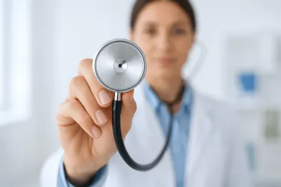 Clinician Holding Stethoscope in Bright Exam Room