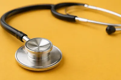Close Up Stethoscope on Mustard Surface