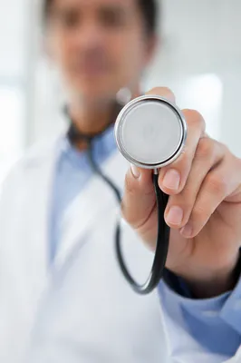 Clinician Holding Stethoscope in Exam Room