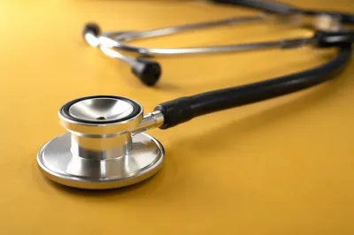 Close-Up Stethoscope on Mustard Yellow Surface