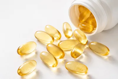 Golden Softgel Capsules on White Surface