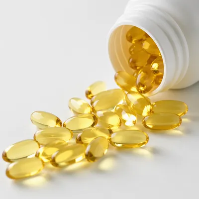 Golden Softgel Capsules Spilling From Pharmacy Bottle