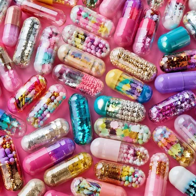 Colorful Medicine Capsules on Pink Background