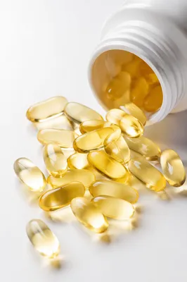 Golden Softgel Capsules on Clean Pharmacy Surface