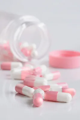 Pink and White Capsules on Pharmacy Surface
