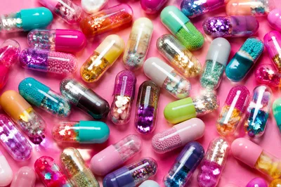 Colorful Capsules on Bright Pink Surface