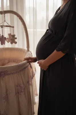 Expectant Mother Beside Nursery Bassinet