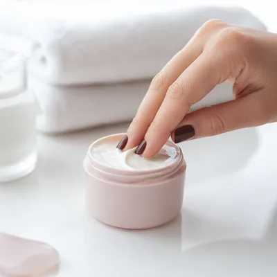 Close-Up Hand Dipping Face Cream