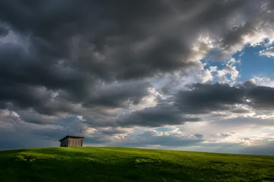 Green Countryside Field Under Storm Clouds