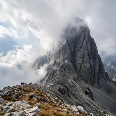 Misty Alpine Hikers Beneath Jagged Peak