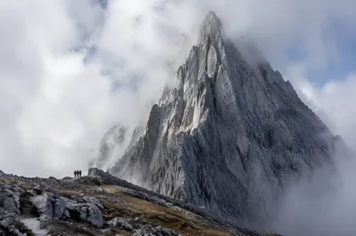 Misty Alpine Hikers Beneath Jagged Peak
