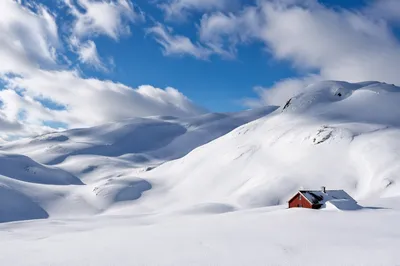 Serene Snowy Hills with Red Cabin