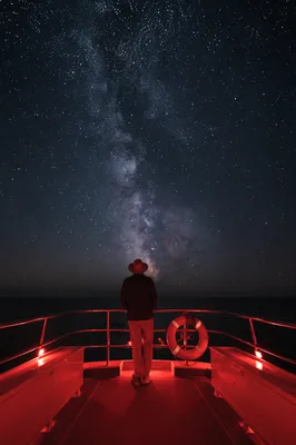 Solitary Figure Beneath Starry Ocean Night