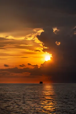 Golden Sunset Ocean Horizon with Distant Boat