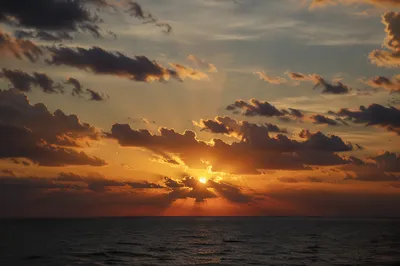 Golden Sunset Ocean Horizon Under Cloudy Sky