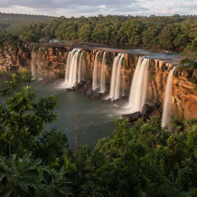 Clear River Waterfalls Through Emerald Forest