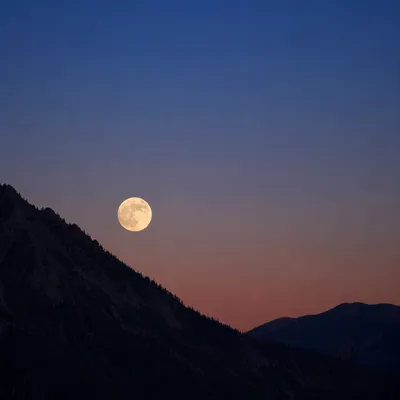 Full Moon Rising Over Mountain Silhouettes