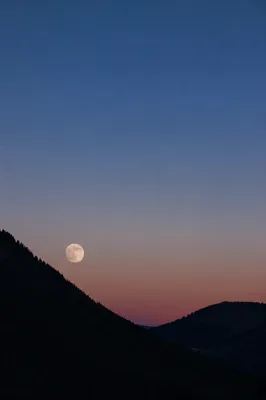 Full Moon Rising Over Twilight Mountains