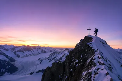 Climber and Summit Cross at Sunrise
