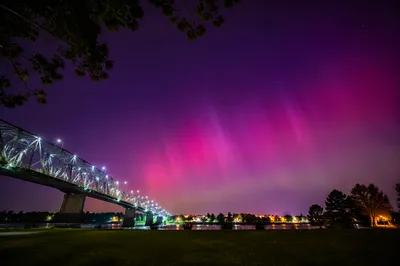 Vivid Aurora Borealis Over Riverside Town