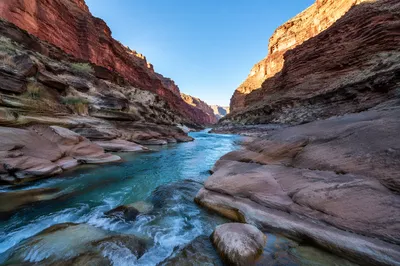 Turquoise River Through Sunlit Canyon Rocks