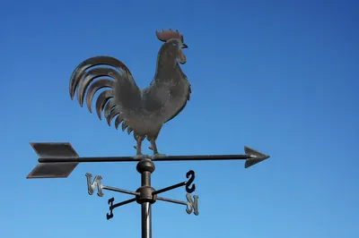 Rustic Rooster Weather Vane Against Blue Sky