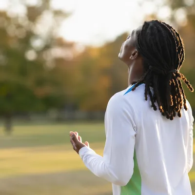 Young Person in Sunlit Park Portrait