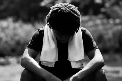Young Man Seated Outdoors in Reflection