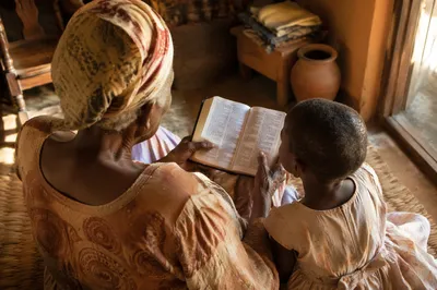 African Grandmother Reading Bible to Grandchild