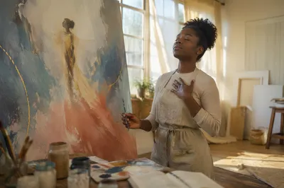 Young Artist Painting in Sunlit Studio