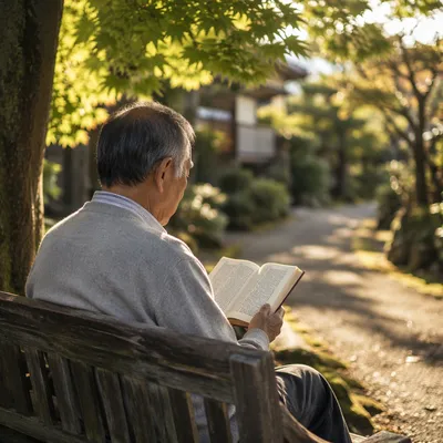 Elderly Asian Man Reading Bible Outdoors