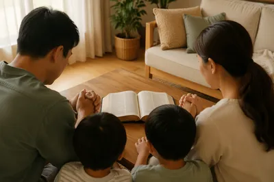 Asian Family Gathered Around Open Bible