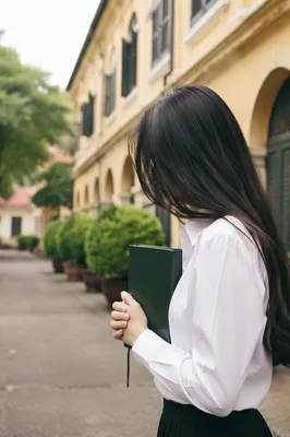 Asian Student Praying with Bible on Campus