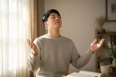 Young East Asian Adult with Raised Hands