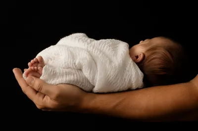 Peaceful Newborn Sleeping in Protective Arms