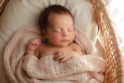 Sleeping Newborn in Woven Bassinet