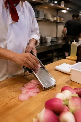 Chef Slicing Radishes in Professional Kitchen
