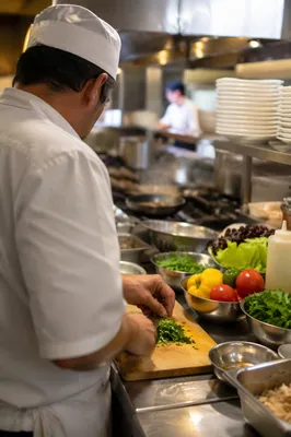 Chef Slicing Fresh Vegetables in Kitchen