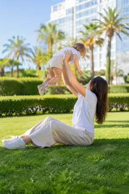 Joyful Parent Lifting Toddler in Sunny Park