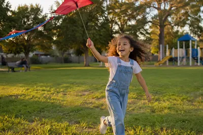 Joyful Girl Running in Neighborhood Park