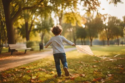 Happy Child Running With Kite in Park