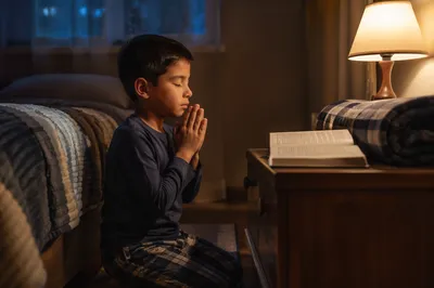 Young Boy Praying Beside Bed